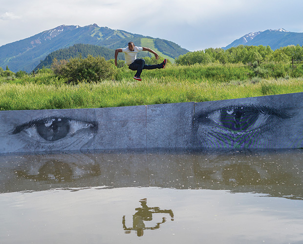 man jumping over mural