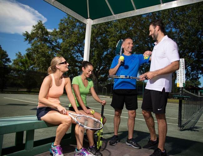 Group of tennis player on tennis court chatting