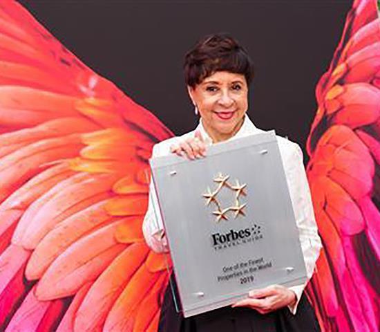 Shelia holding a Forbes award. 