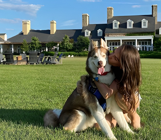 Doggy getting kisses in grass