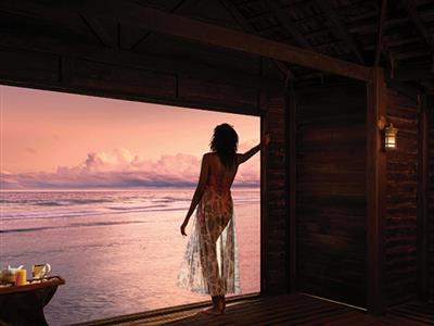 woman looking out at ocean at dusk