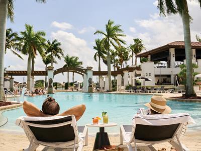 couple by pool lounging in chairs