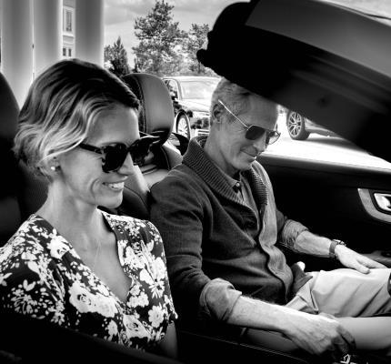 Couple riding in a car together with sunglasses on