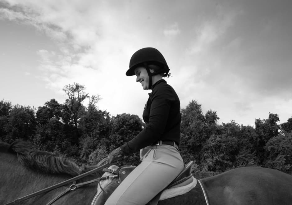 Woman riding a horse in full jockey gear