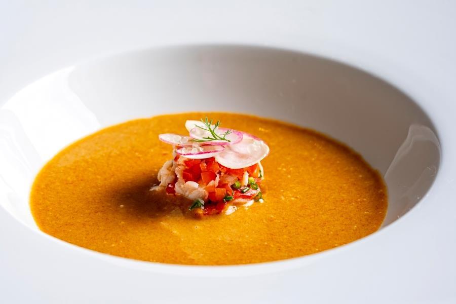 A bowl of food with orange sauce