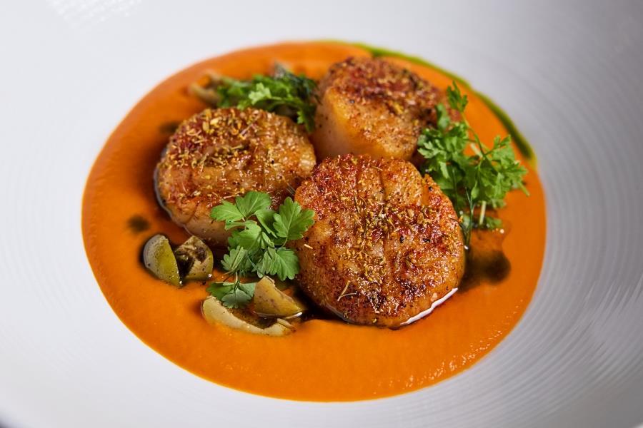 A plate of food that has an orange sauce