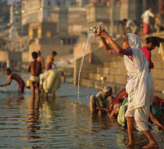 people praying and washing in water