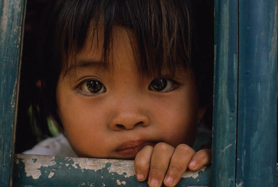 child looking through wood panel