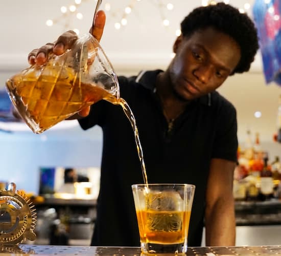 Bartender pours a drink infused with PGA honey
