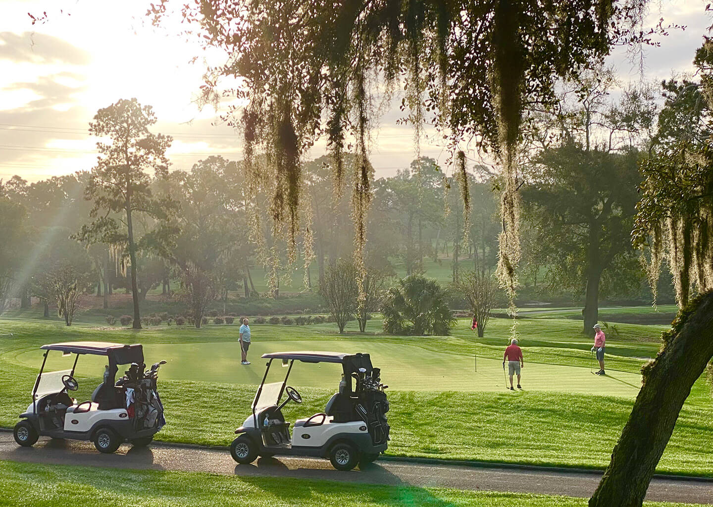 Two golf carts on a paved cart path