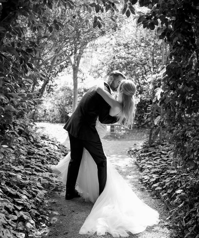 A bride and groom kissing in black and white