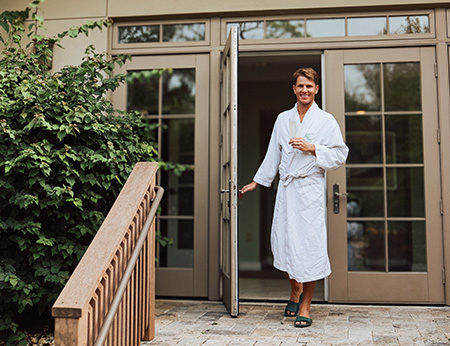 man walking out of the spa in a robe