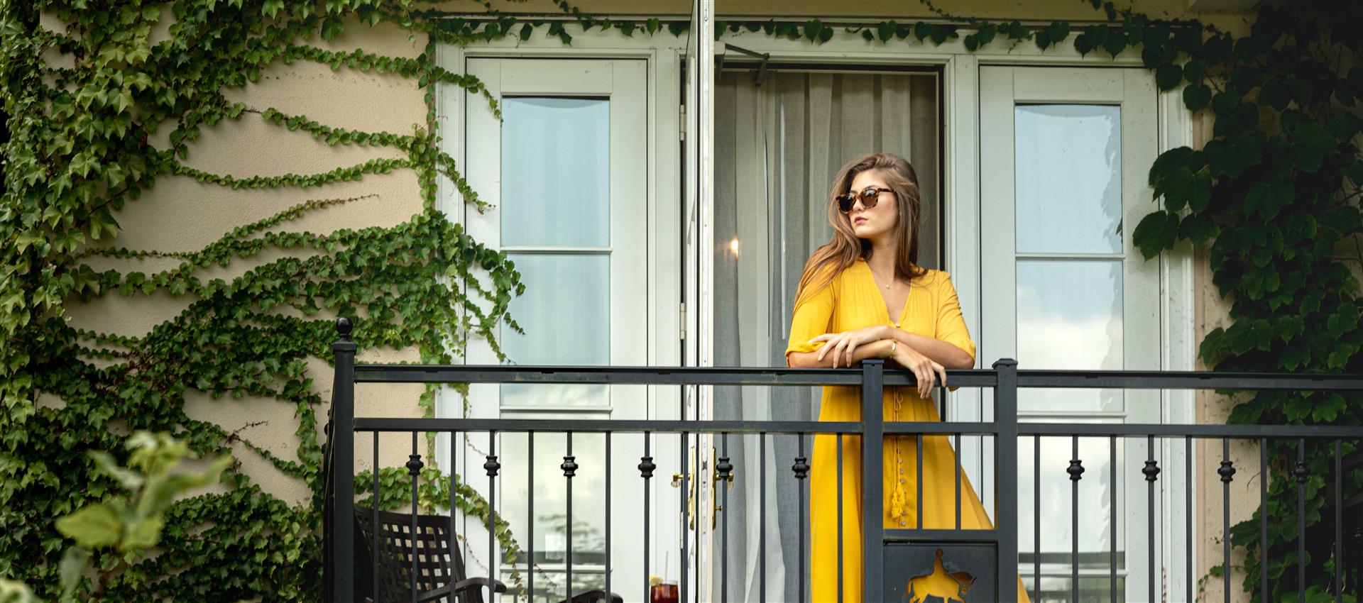A woman standing on a balcony at Salamander Middleburg